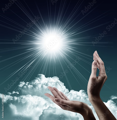 Hands, sun and blue sky with copyspace showing freedom or solar power concept photo