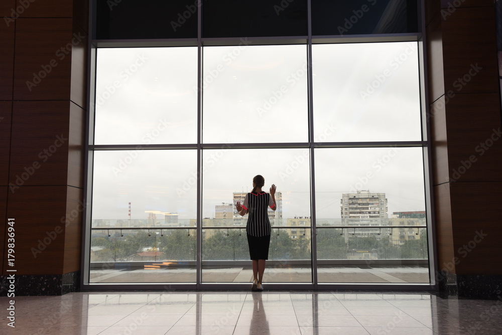 Fototapeta premium Frustrated dreming young girl woman worry thinking silhouette near of window in rainy day