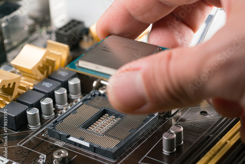 Technician plug in CPU microprocessor to motherboard socket