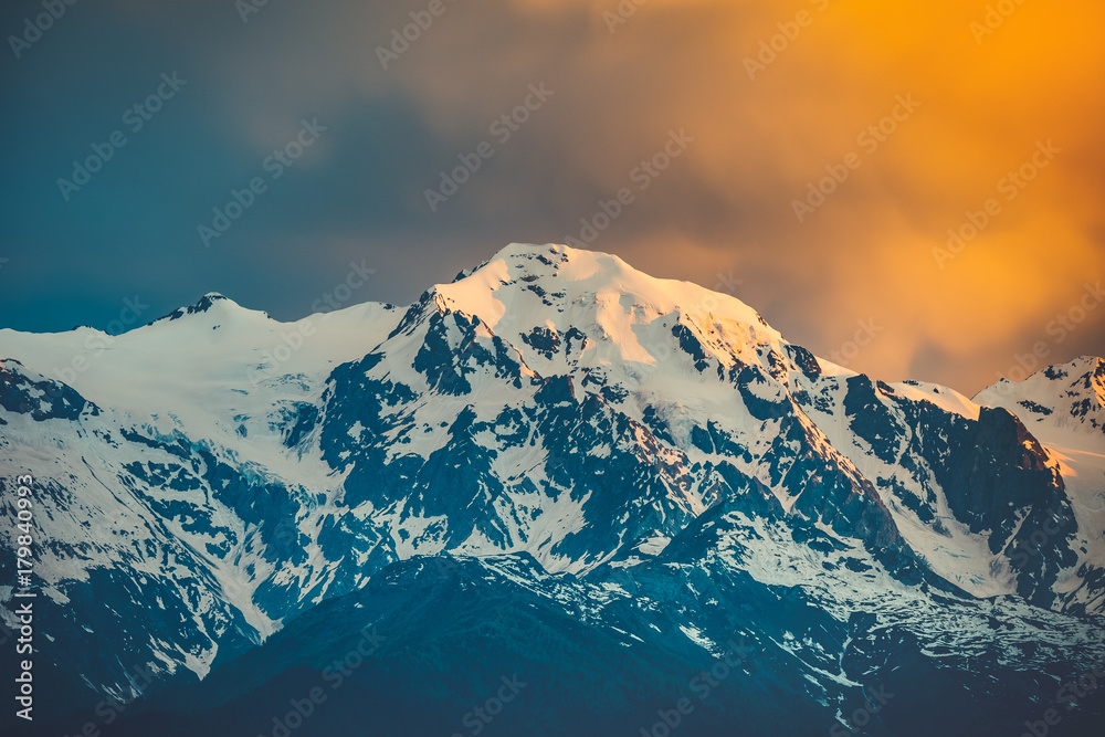 Beautiful sunset over the snowy mountain peak. Nature landscape scene. Travel background. Holiday, travel, sport, recreation. Main Caucasian ridge, Svaneti, Georgia. Retro toning filter
