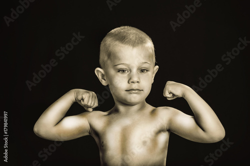 baby shows muscles, black and white photo