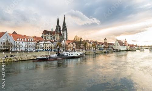 Regensburg im morgen Licht an einem Sommertag mit Promenade und Dom und Steinerne Brücke © stgrafix