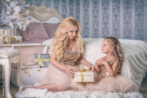 Mother gives a Christmas gift gift to her daughter photo