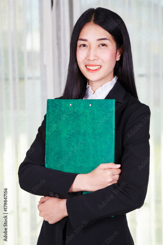 business woman standing with arms crossed and holding a clipboard business woman standing with arms crossed and holding a clipboard
