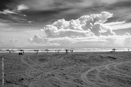 parasols at the Indian ocean shore, people silhouettes - black and white, high contrast photo