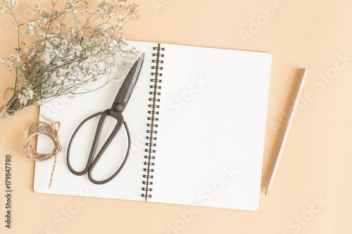 flat lay image of workplace with empty notebook,Yellow paper ground with notebook with pencil and old scissors