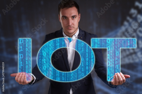 The concept of business, technology, the Internet and the network. Young businessman showing inscription: IOT