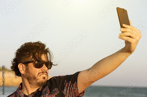 Obraz na plátně O homem feio usa camisa azul florida e oculos no dia ensolarado e quente na praia