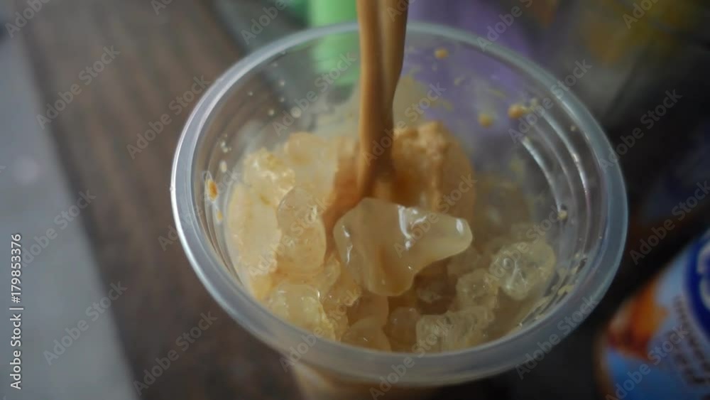 Slow motion of pouring coffee in to a cup with ice. Slow motion of pouring coffee in to a cup with ice.