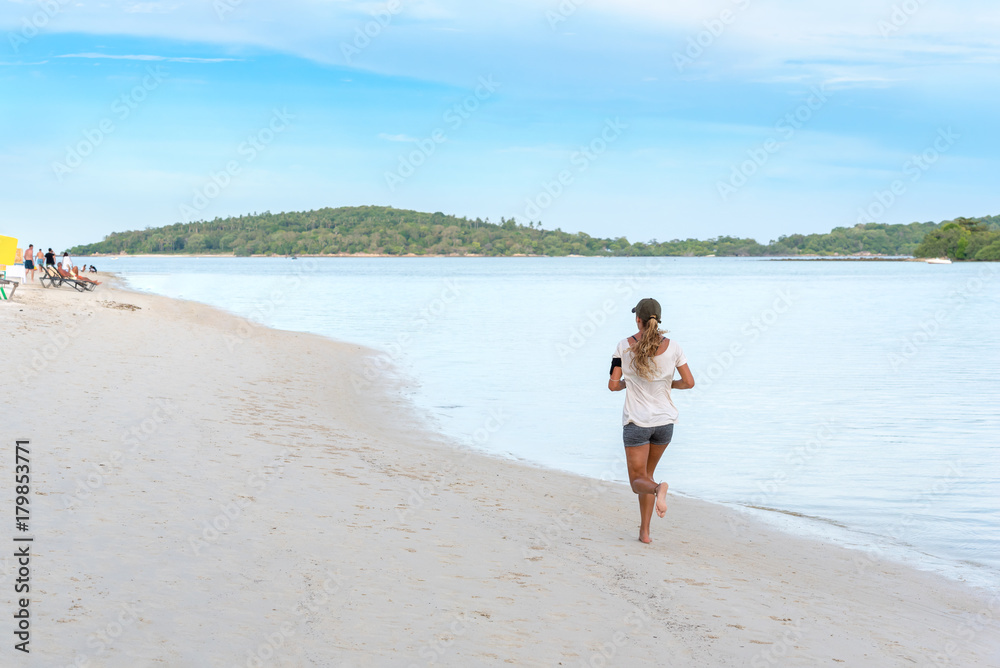 Healthy woman running on beach at Koh Samui island morning. Healthy woman running on beach at Koh Samui island morning.