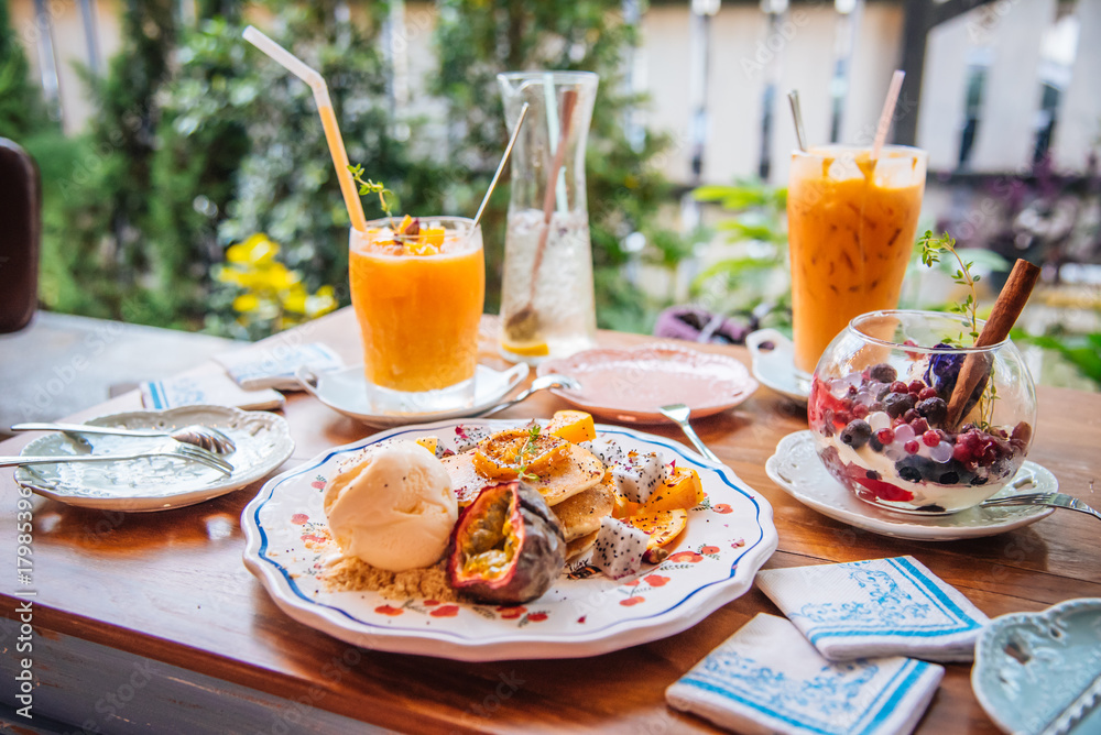Sweet Pancakes with honey and vanilla ice cream Fruit with Orange focus on pancake Sweet Pancakes with honey and vanilla ice cream Fruit with Orange focus on pancake