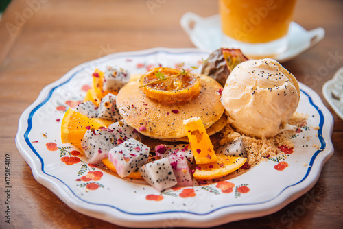 Sweet Pancakes with honey and vanilla ice cream Fruit with Orange focus on pancake