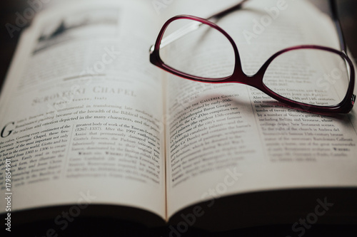 Red glasses sitting on book