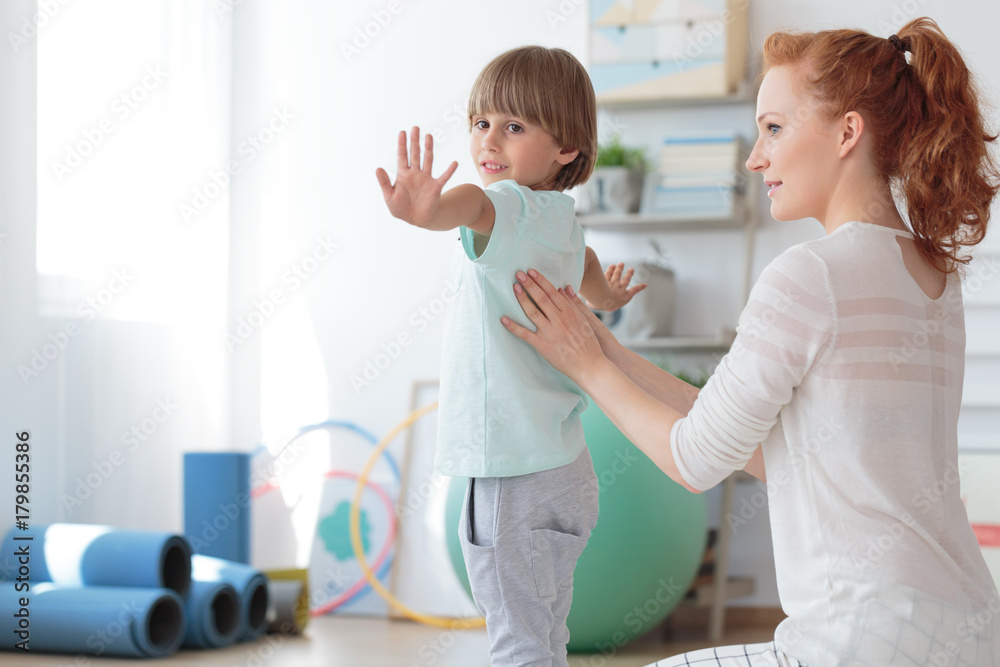 Child during physical therapy session - obrazy, fototapety, plakaty 