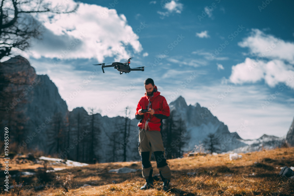 Nature photographer flying a drone in mountains, Julian Alps, in Europe.  foto de Stock | Adobe Stock