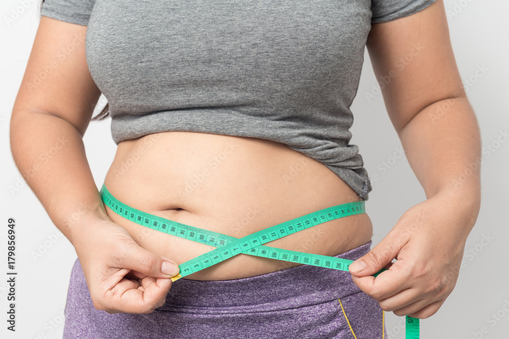 Fototapeta premium Overweight woman check out his body fat with green measuring tape for obesity on gray background, Healthy concept