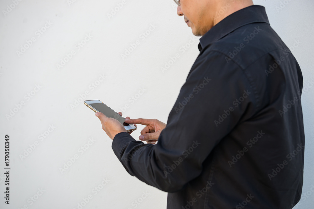 Portrait of asian Businessman play smartphone on white wall Portrait of asian Businessman play smartphone on white wall