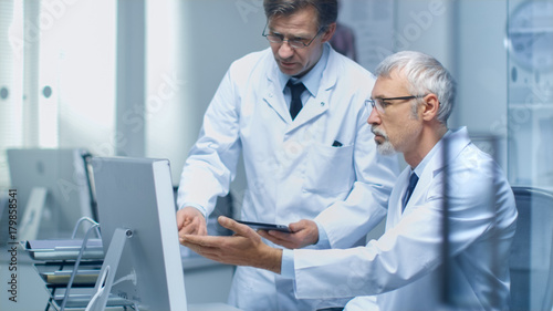 Photos Two Senior Medical Practitioners Discussing Medical Issues over Desktop Computer