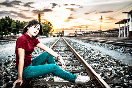 Portrait of asian hipster girl on sunset at railway HDR style