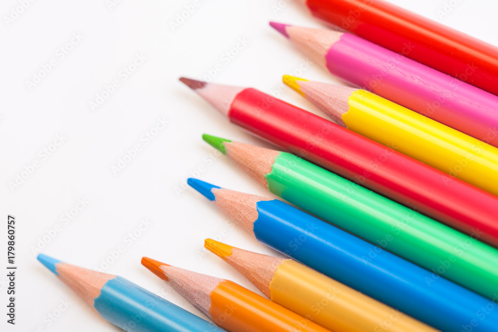 Colored pencils lying diagonally on a white background. Photo calendar Wooden objects for creativity.