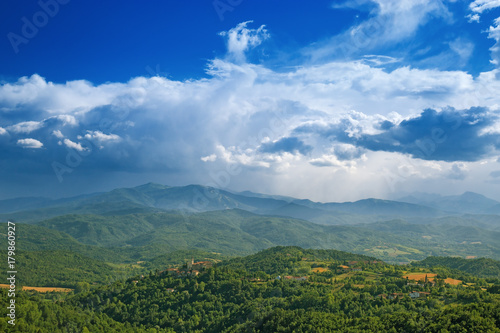 View on hilly terrain of the Alba region in nothern Italy after a storm. Huge dark clouds in the storm sky.