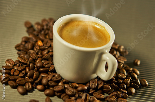 Hot espresso coffee between coffee beans