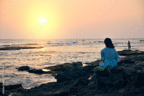 woman on the beach admiring the sunset © badahos