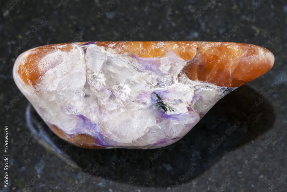 polished charoite and Tinaksite gemstone on dark polished charoite and Tinaksite gemstone on dark
