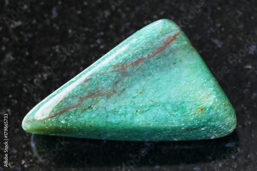 tumbled fuchsite (chrome mica) gemstone on dark photo