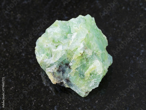 rough crystal of chrysopal gemstone on dark photo