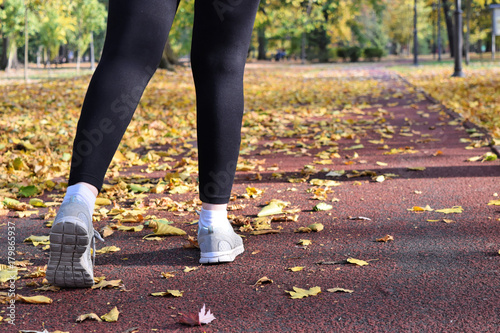 Recreation in the park during fall season - jogging and walking