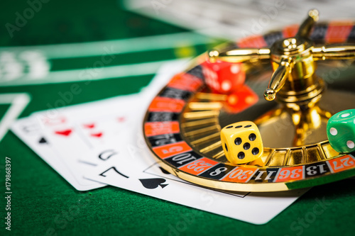 Vintage casino chips on green table with cards.