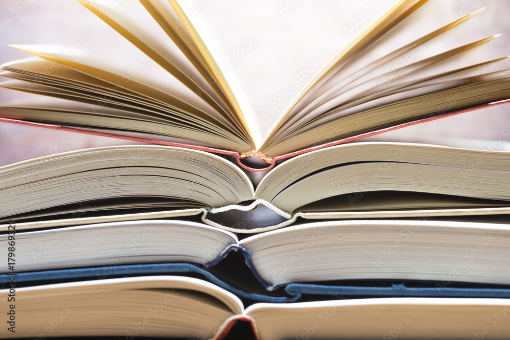 Several textbooks with white sheets opened in the middle Several textbooks with white sheets opened in the middle