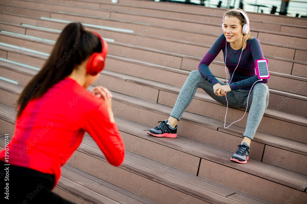 Obraz premium Attractive woman exercising with a personal trainer outside in the morning