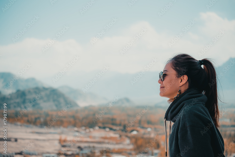 Naklejka premium Portrait image of a beautiful Asian woman standing on the top of view point with Leh city background