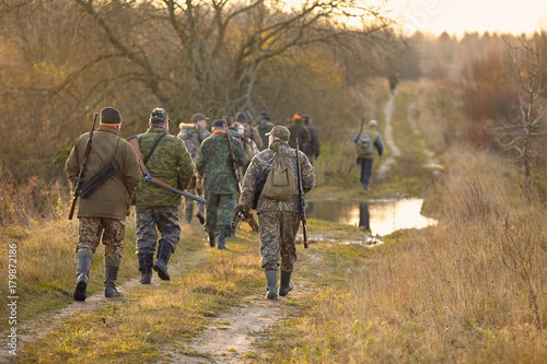 Photographie group of hunters in forest
