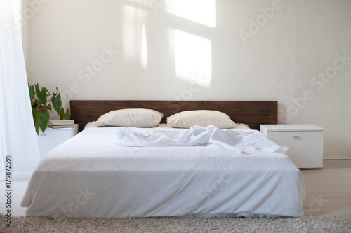 bedroom with a bed in a white room © dmitriisimakov