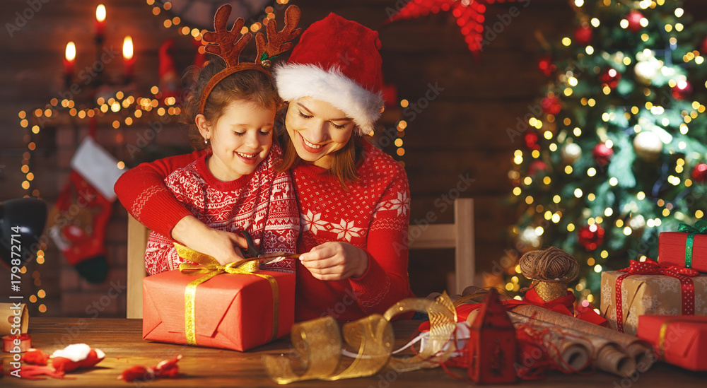happy family mother and child pack Christmas gifts. happy family mother and child pack Christmas gifts.
