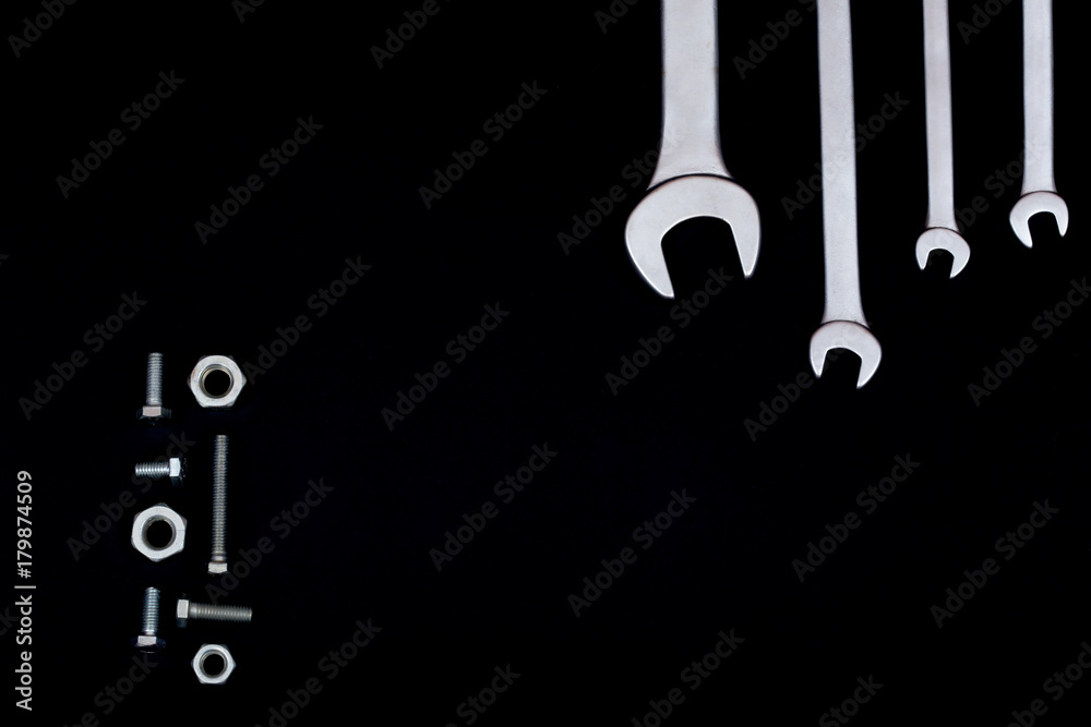 Spanners with screws and bolts on a black background Spanners with screws and bolts on a black background