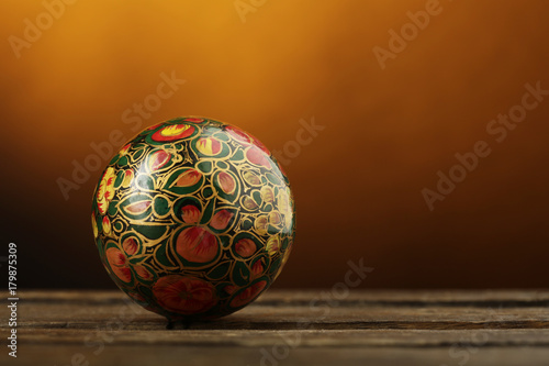 Palla di natale decorativa color fantasia sopra superficie in legno su sfondo arancio