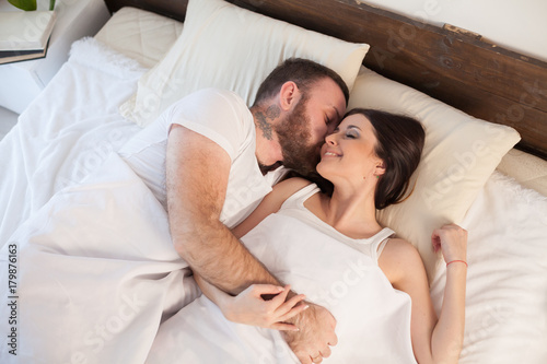 man wakes a woman in the bedroom in the morning weekend photo