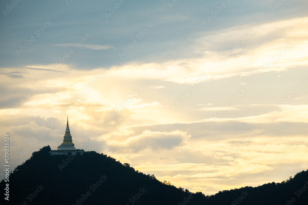 Beautiful silhouette shot of golden pagoda and the temple on the high mountain at sunset.