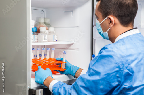 Young male scientist and laboratory freezer