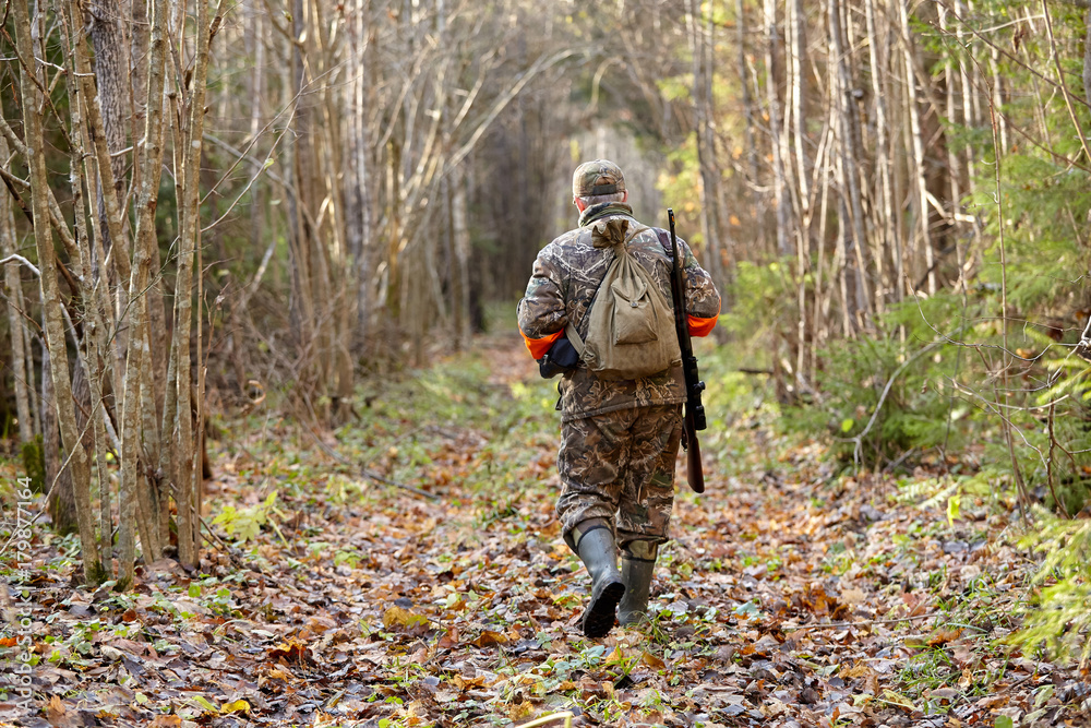 Hunter in camouflage clothes with hunting rifle during a winter hunting Hunter in camouflage clothes with hunting rifle during a winter hunting