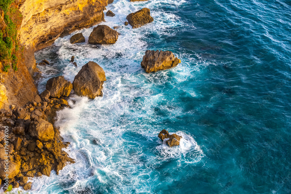 Εκτύπωση καμβά Waves of the Indian Ocean and the azure sea break on the rocks of the island, forming a white foam around the stones