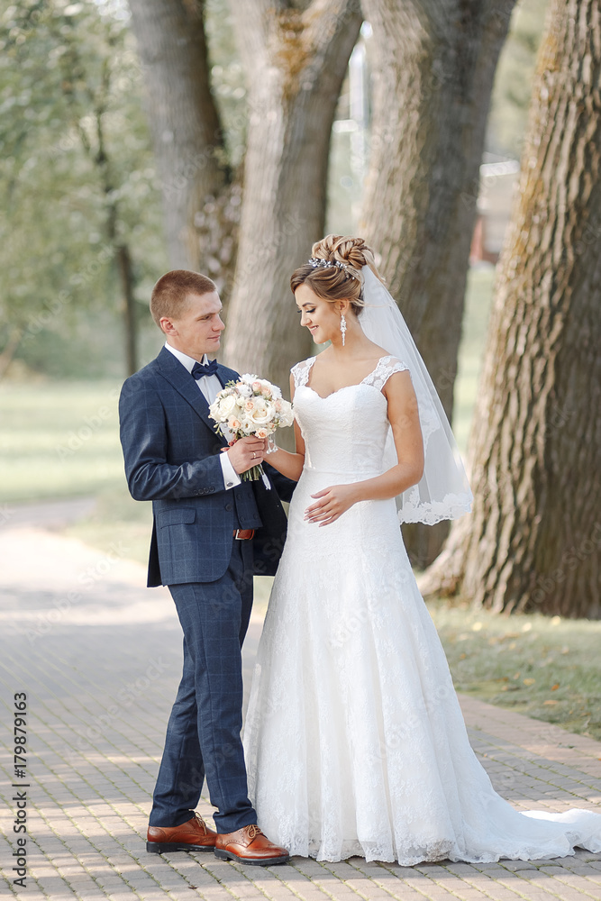 Hrodna, Belarus - September 9, 2017: The newly-married couple holding hands. Hrodna, Belarus - September 9, 2017: The newly-married couple holding hands.