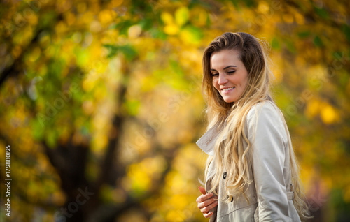 Cheerful woman walking in the city under colorful autumn trees 2
