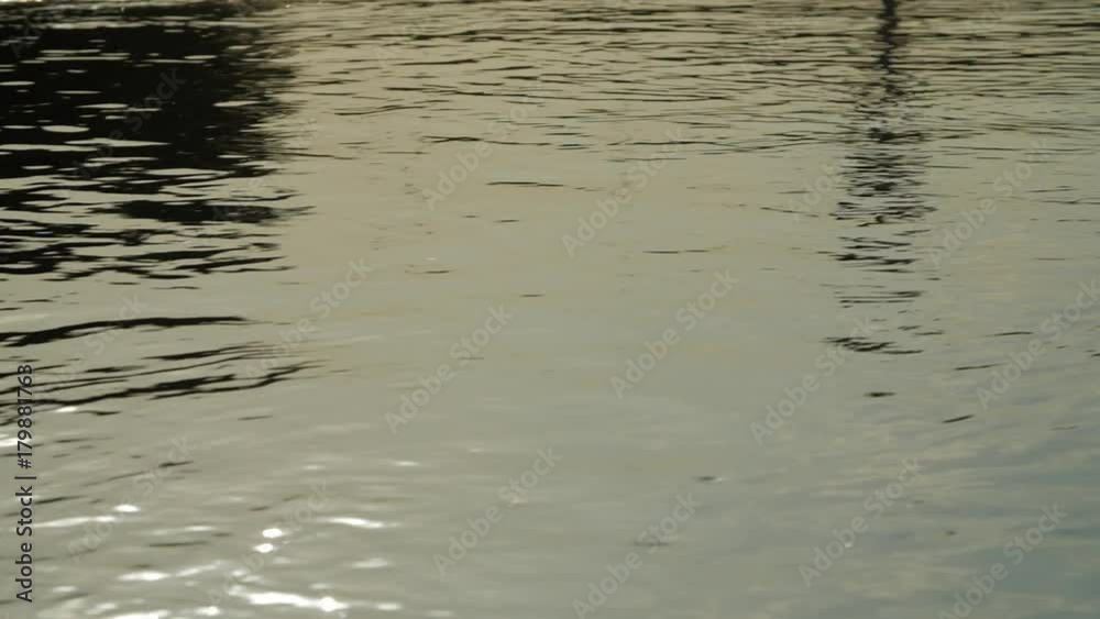 River water surface. Close-up of texture of nature works ripples on the water. Background meditative and hypnotic effect. River water surface. Close-up of texture of nature works ripples on the water. Background meditative and hypnotic effect.