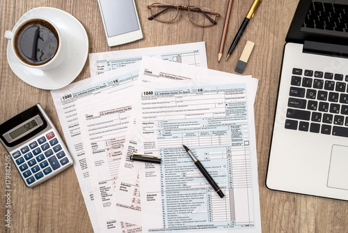 1040 tax form, laptop, glasses, coffee on desk