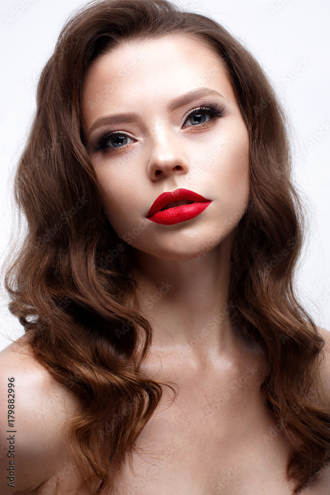A young girl with a Hollywood wave and classic makeup. Beautiful model with red lips and arrows on eyes. Evening makeup and hairstyle. Beauty of the face. White isolated background. Shining skin. A young girl with a Hollywood wave and classic makeup. Beautiful model with red lips and arrows on eyes. Evening makeup and hairstyle. Beauty of the face. White isolated background. Shining skin.